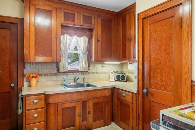 99 Hill St, Biddeford, ME 04005 - kitchen featuring brown cabinets, light countertops, and tasteful backsplash