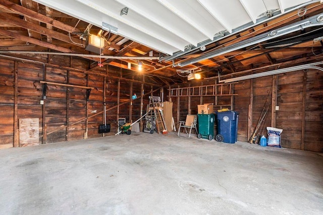 99 Hill St, Biddeford, ME 04005 - garage featuring a garage door opener and wood walls