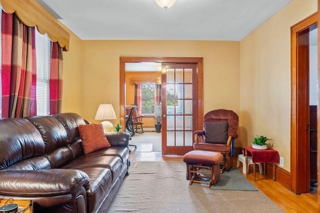 99 Hill St, Biddeford, ME 04005 - living room featuring wood finished floors, french doors, and a baseboard heating unit