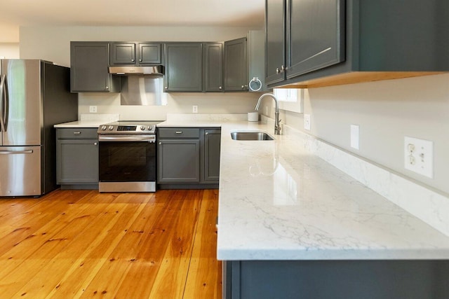 7 Lucas Ct, Bristol, ME 04539 - kitchen featuring appliances with stainless steel finishes, gray cabinets, light stone counters, light wood-type flooring, and under cabinet range hood