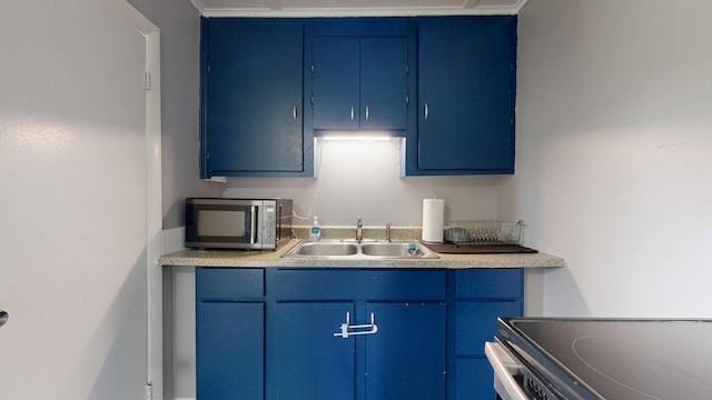 28 Stewart St, Lewiston, ME 04240 - kitchen with blue cabinets, stainless steel appliances, and light countertops