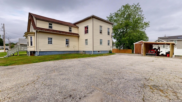 28 Stewart St, Lewiston, ME 04240 - back of house with a detached carport and asphalt driveway