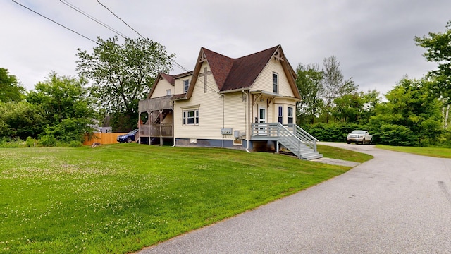 28 Stewart St, Lewiston, ME 04240 - view of home's exterior featuring a lawn, asphalt driveway, and view of scattered trees