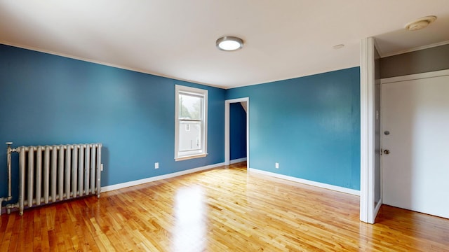 28 Stewart St, Lewiston, ME 04240 - spare room featuring radiator heating unit, wood finished floors, and ornamental molding