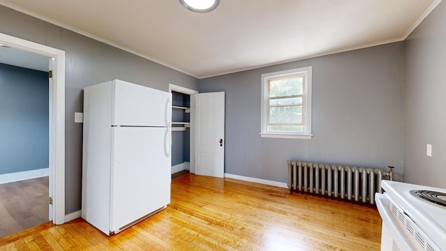 28 Stewart St, Lewiston, ME 04240 - bedroom featuring freestanding refrigerator, radiator, light wood-style floors, ornamental molding, and a closet