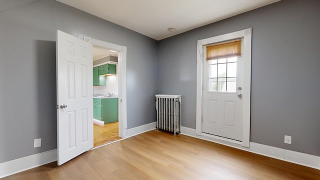 28 Stewart St, Lewiston, ME 04240 - doorway to outside with light wood-style floors and radiator