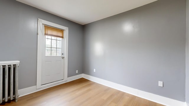 28 Stewart St, Lewiston, ME 04240 - doorway to outside with radiator and light wood-style flooring