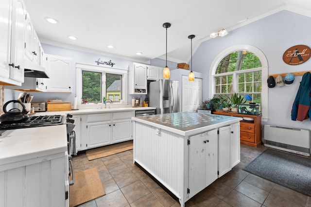118 Gore Rd, Palermo, ME 04354 - kitchen with lofted ceiling, a center island, radiator, stainless steel appliances, and white cabinetry