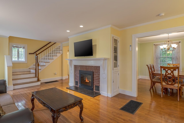 135 State Highway 3, Bar Harbor, ME 04609 - living area featuring stairs, wood finished floors, crown molding, a chandelier, and a brick fireplace