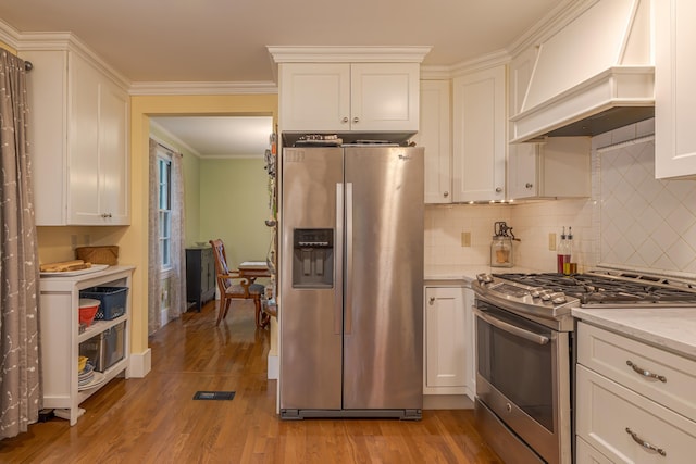 135 State Highway 3, Bar Harbor, ME 04609 - kitchen with appliances with stainless steel finishes, custom range hood, light wood finished floors, white cabinetry, and decorative backsplash