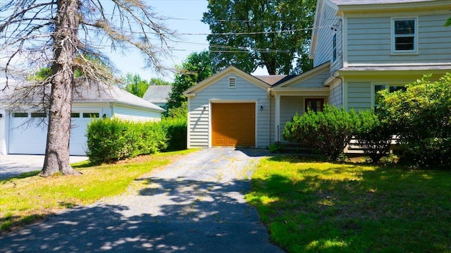 49 Bardwell St, Lewiston, ME 04240 - view of front facade featuring a garage, asphalt driveway, and a front lawn