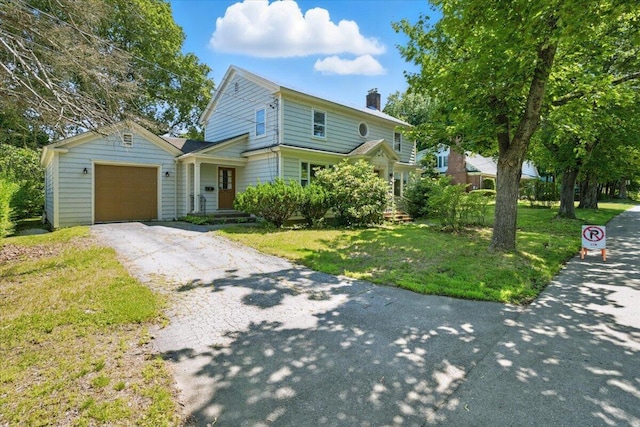 49 Bardwell St, Lewiston, ME 04240 - traditional-style house with asphalt driveway, a garage, a chimney, and a front lawn
