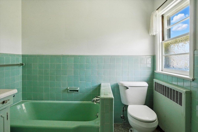 49 Bardwell St, Lewiston, ME 04240 - bathroom with radiator, a bath, tile walls, a wainscoted wall, and vanity