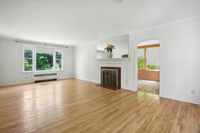 49 Bardwell St, Lewiston, ME 04240 - unfurnished living room with light wood-style flooring, a fireplace with flush hearth, and radiator heating unit