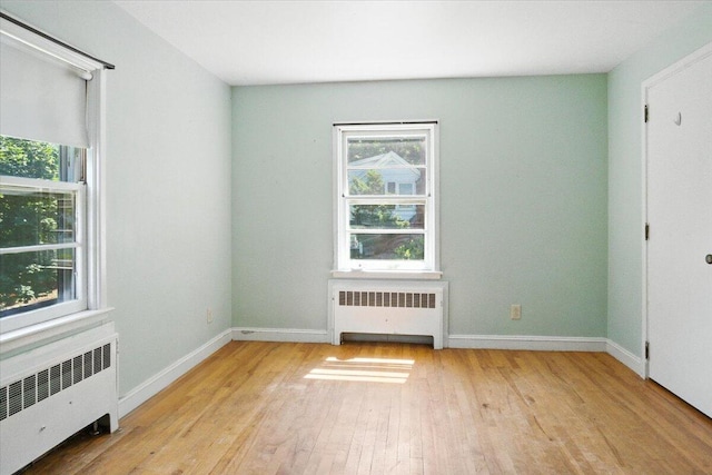 49 Bardwell St, Lewiston, ME 04240 - empty room featuring radiator heating unit, plenty of natural light, and wood-type flooring