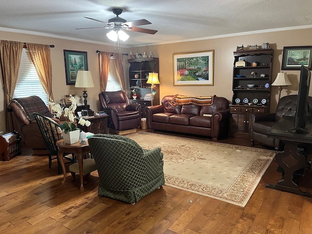 living room featuring wood-type flooring, ornamental molding, ceiling fan, and plenty of natural light