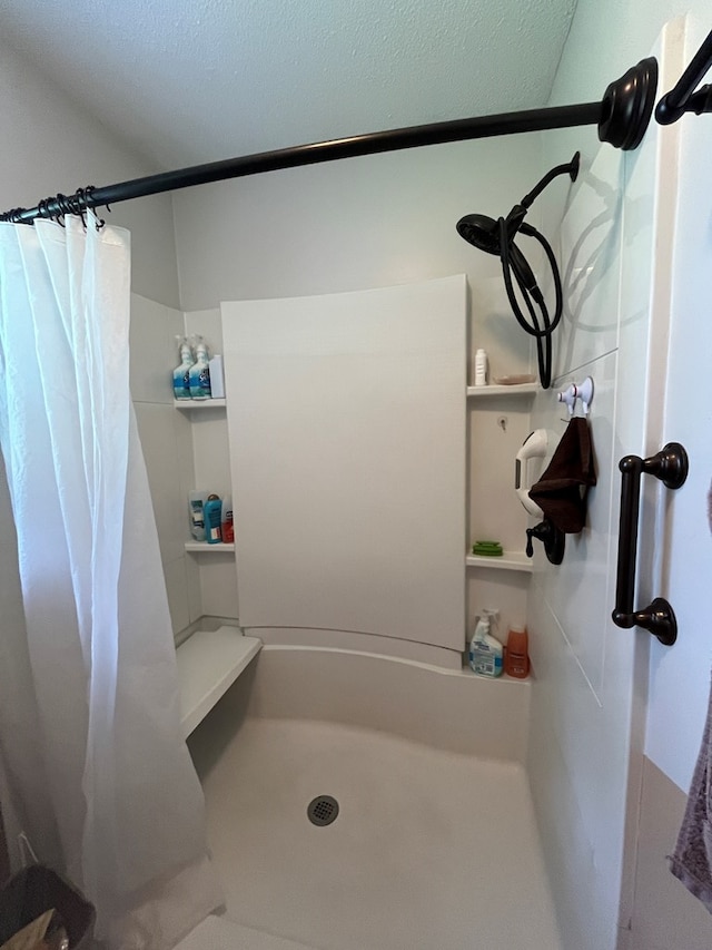 bathroom featuring curtained shower and a textured ceiling