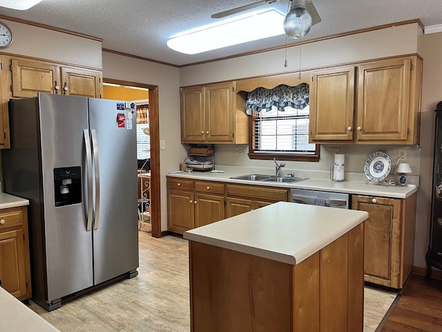 kitchen featuring sink, ornamental molding, stainless steel appliances, and light hardwood / wood-style floors