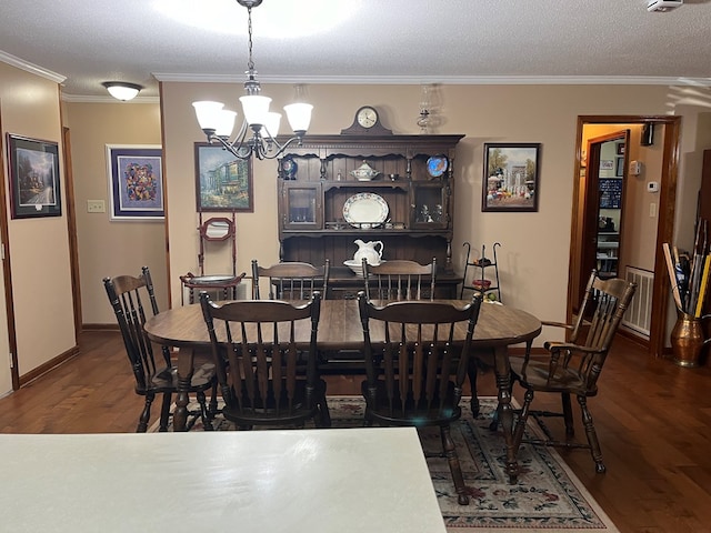 dining room featuring an inviting chandelier, crown molding, dark wood-type flooring, and a textured ceiling