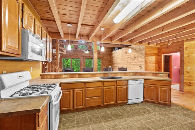 3691 Flagpole Rd, Ellijay, GA 30540 - kitchen featuring white appliances, a sink, wood walls, brown cabinets, and light countertops