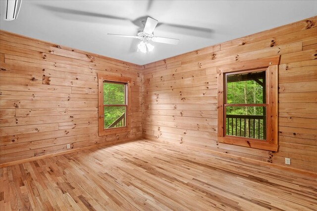 3691 Flagpole Rd, Ellijay, GA 30540 - empty room with wood finished floors, healthy amount of natural light, wood walls, and ceiling fan