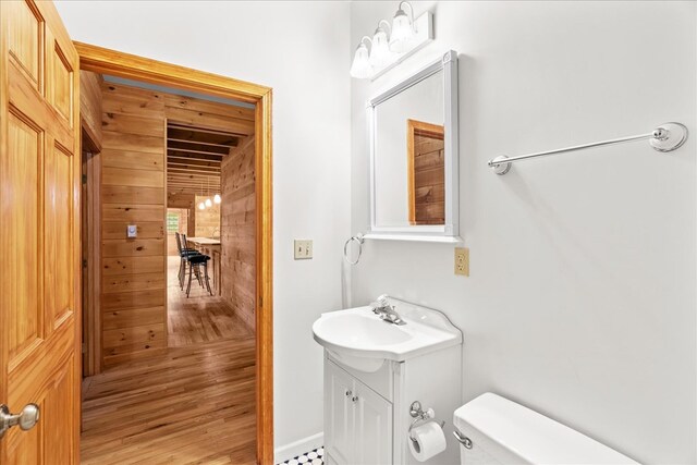 3691 Flagpole Rd, Ellijay, GA 30540 - half bath featuring wooden walls, toilet, vanity, and wood finished floors