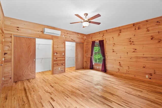 3691 Flagpole Rd, Ellijay, GA 30540 - unfurnished bedroom featuring a wall mounted air conditioner, wood walls, wood finished floors, and ceiling fan