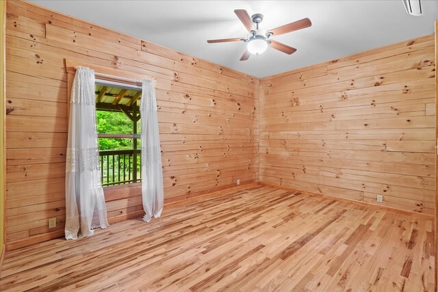3691 Flagpole Rd, Ellijay, GA 30540 - empty room with wooden walls, wood finished floors, and ceiling fan