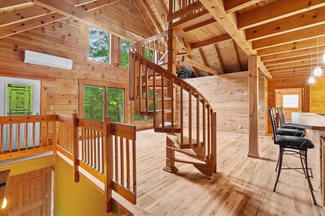 3691 Flagpole Rd, Ellijay, GA 30540 - stairway with a wall mounted air conditioner, wood walls, hardwood / wood-style flooring, wood ceiling with exposed beams, and high vaulted ceiling