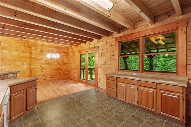 3691 Flagpole Rd, Ellijay, GA 30540 - kitchen with wooden ceiling with exposed beams, light countertops, wood walls, a chandelier, and brown cabinetry