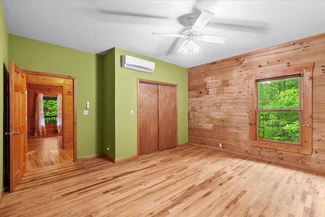 3691 Flagpole Rd, Ellijay, GA 30540 - unfurnished bedroom featuring a wall unit AC, wood finished floors, multiple windows, a closet, and wooden walls