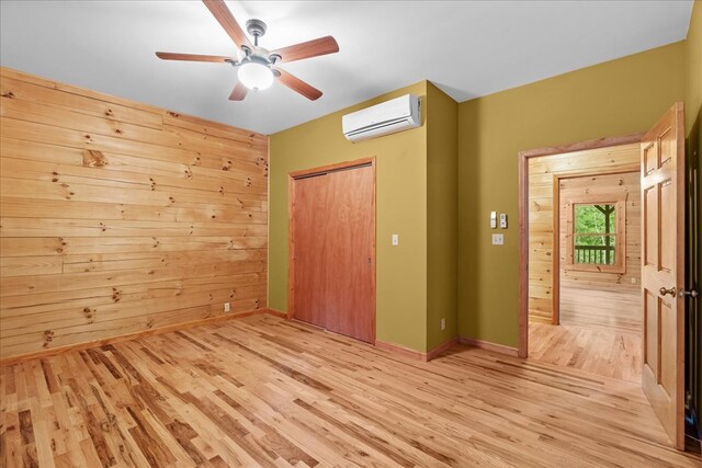 3691 Flagpole Rd, Ellijay, GA 30540 - unfurnished bedroom with a wall mounted air conditioner, light wood-style floors, a closet, ceiling fan, and baseboards