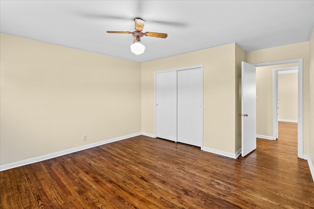 unfurnished bedroom with a closet, wood finished floors, and baseboards