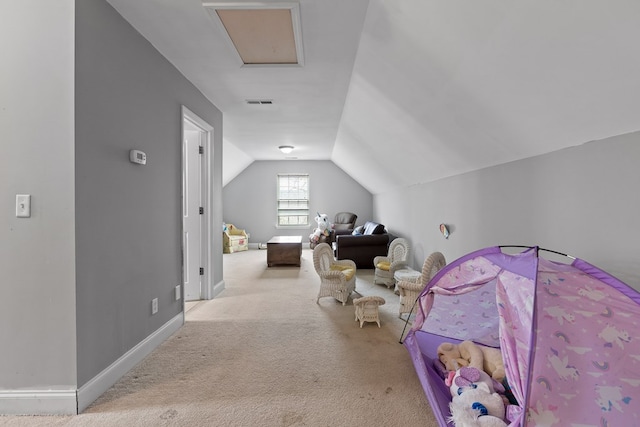 interior space featuring lofted ceiling, light carpet, visible vents, baseboards, and attic access