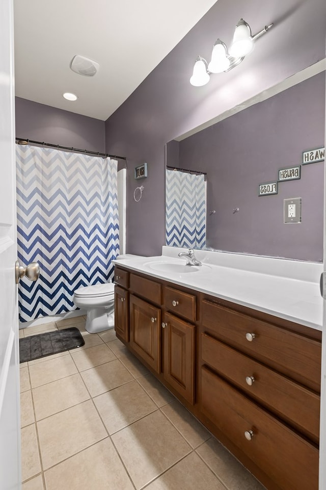 bathroom with toilet, vanity, and tile patterned floors