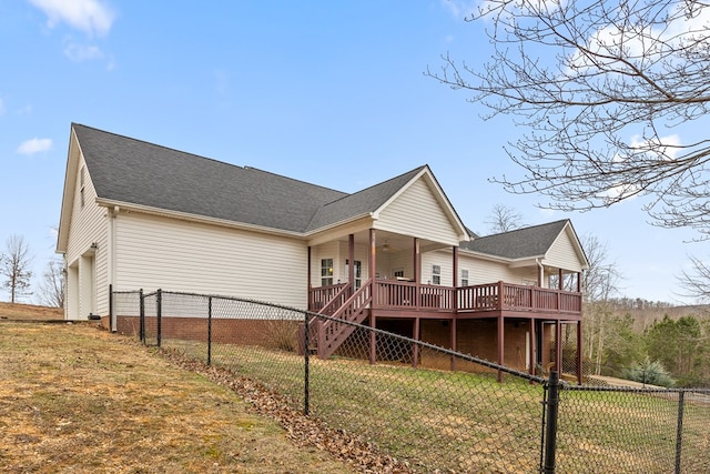 exterior space featuring roof with shingles, stairway, a front yard, fence private yard, and a wooden deck