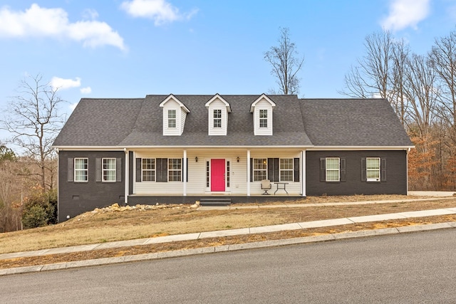 new england style home with covered porch and a shingled roof