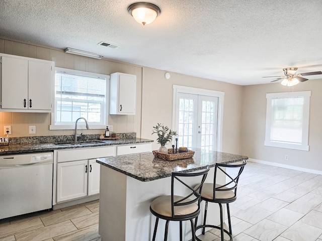 106 Santa Fe Trl NW, Dalton, GA 30721 - kitchen featuring dishwasher, a kitchen bar, white cabinetry, dark stone counters, and a textured ceiling