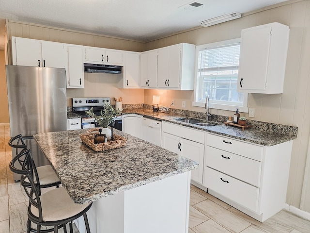 106 Santa Fe Trl NW, Dalton, GA 30721 - kitchen with appliances with stainless steel finishes, under cabinet range hood, dark stone countertops, a breakfast bar, and white cabinets