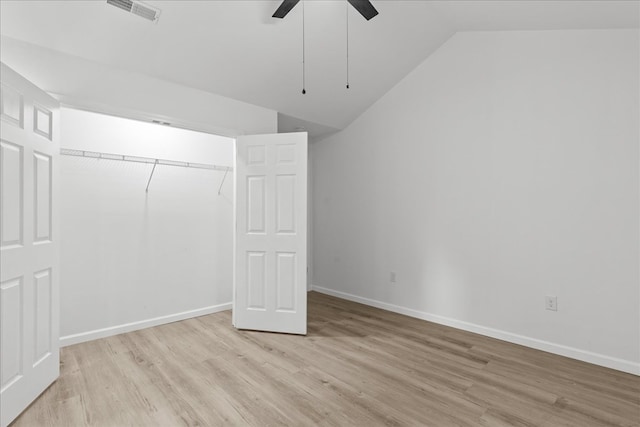 unfurnished bedroom with a ceiling fan, visible vents, vaulted ceiling, baseboards, and light wood-style floors