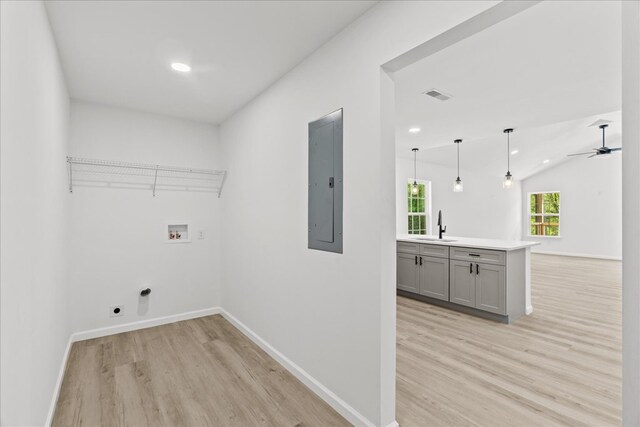 washroom with laundry area, light wood-type flooring, electric panel, washer hookup, and hookup for an electric dryer