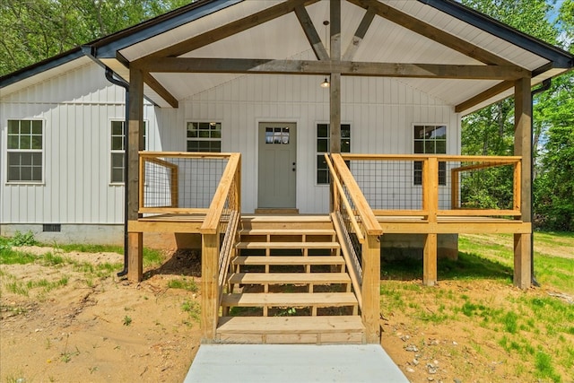 view of exterior entry featuring a porch and crawl space