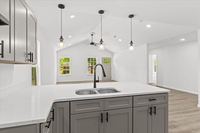 kitchen with open floor plan, gray cabinetry, a healthy amount of sunlight, and a sink