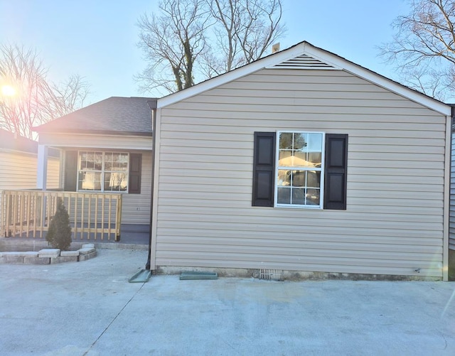 view of side of property featuring covered porch