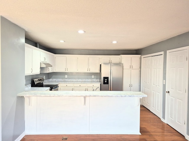 kitchen featuring white cabinetry, appliances with stainless steel finishes, wood-type flooring, and kitchen peninsula