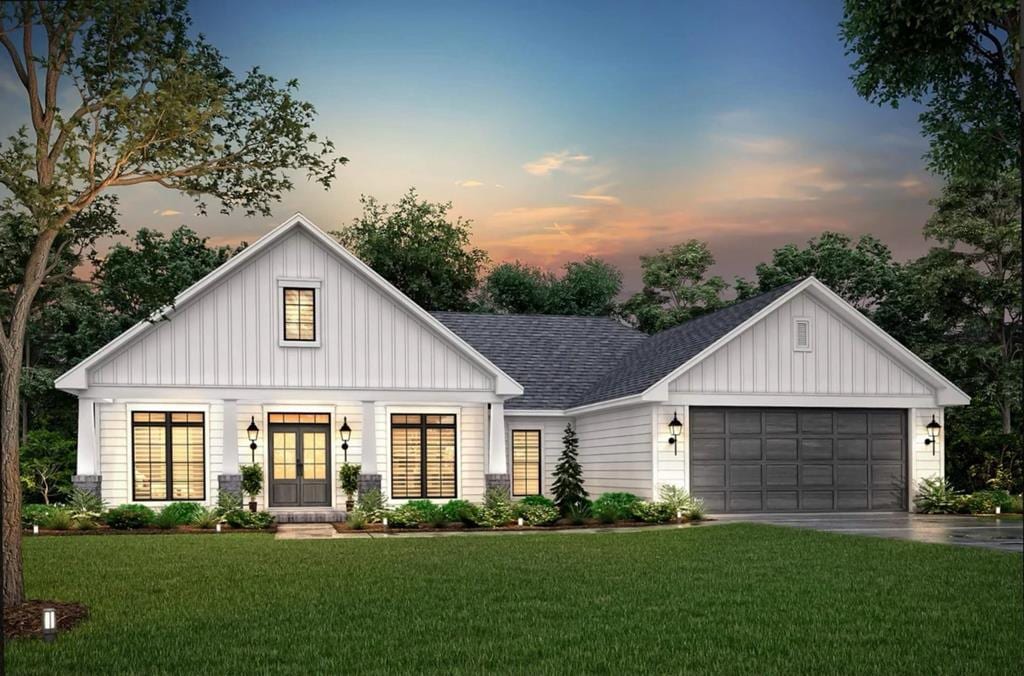 modern inspired farmhouse with driveway, roof with shingles, an attached garage, board and batten siding, and a front yard