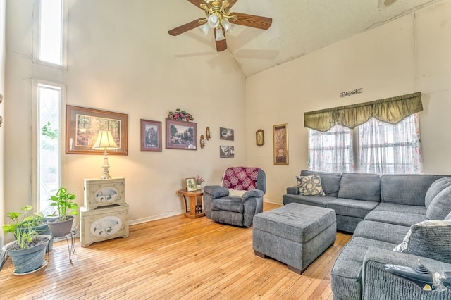 living area featuring wood-type flooring, high vaulted ceiling, and a healthy amount of sunlight