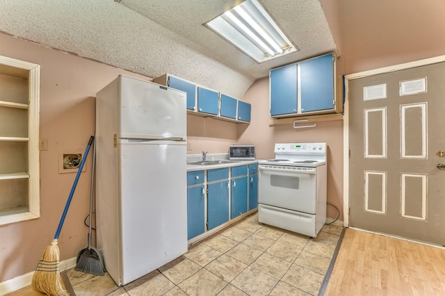 kitchen with blue cabinetry, lofted ceiling, white appliances, a textured ceiling, and a sink