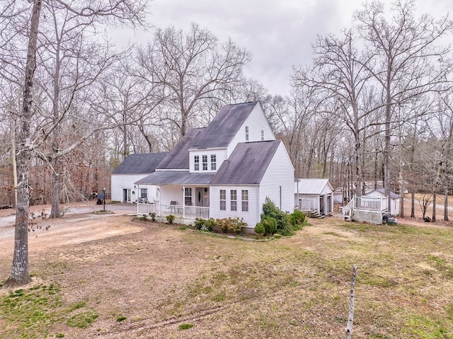 back of house featuring a deck, a lawn, and driveway