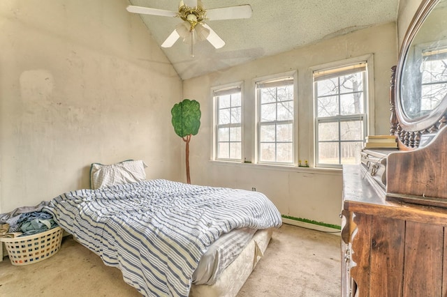 carpeted bedroom with lofted ceiling, multiple windows, a ceiling fan, and a textured ceiling